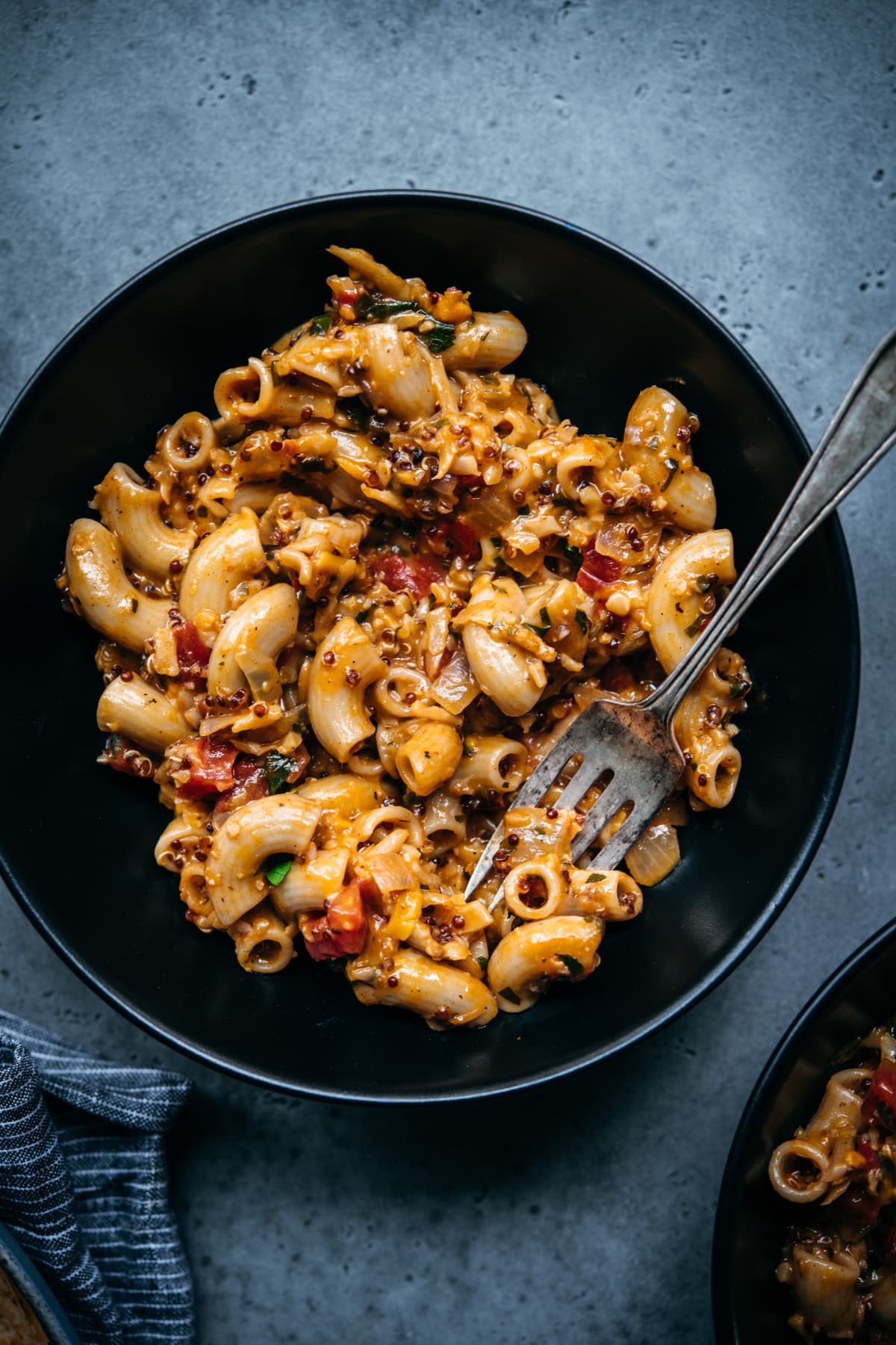 close up overhead view of vegan hamburger helper in a black bowl with fork.