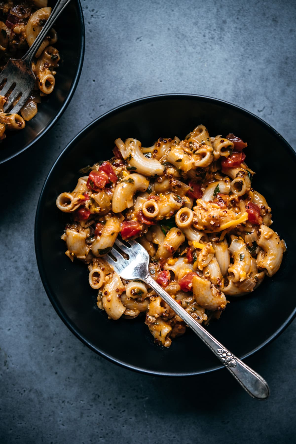 close up overhead view of vegan hamburger helper in a black bowl with fork.