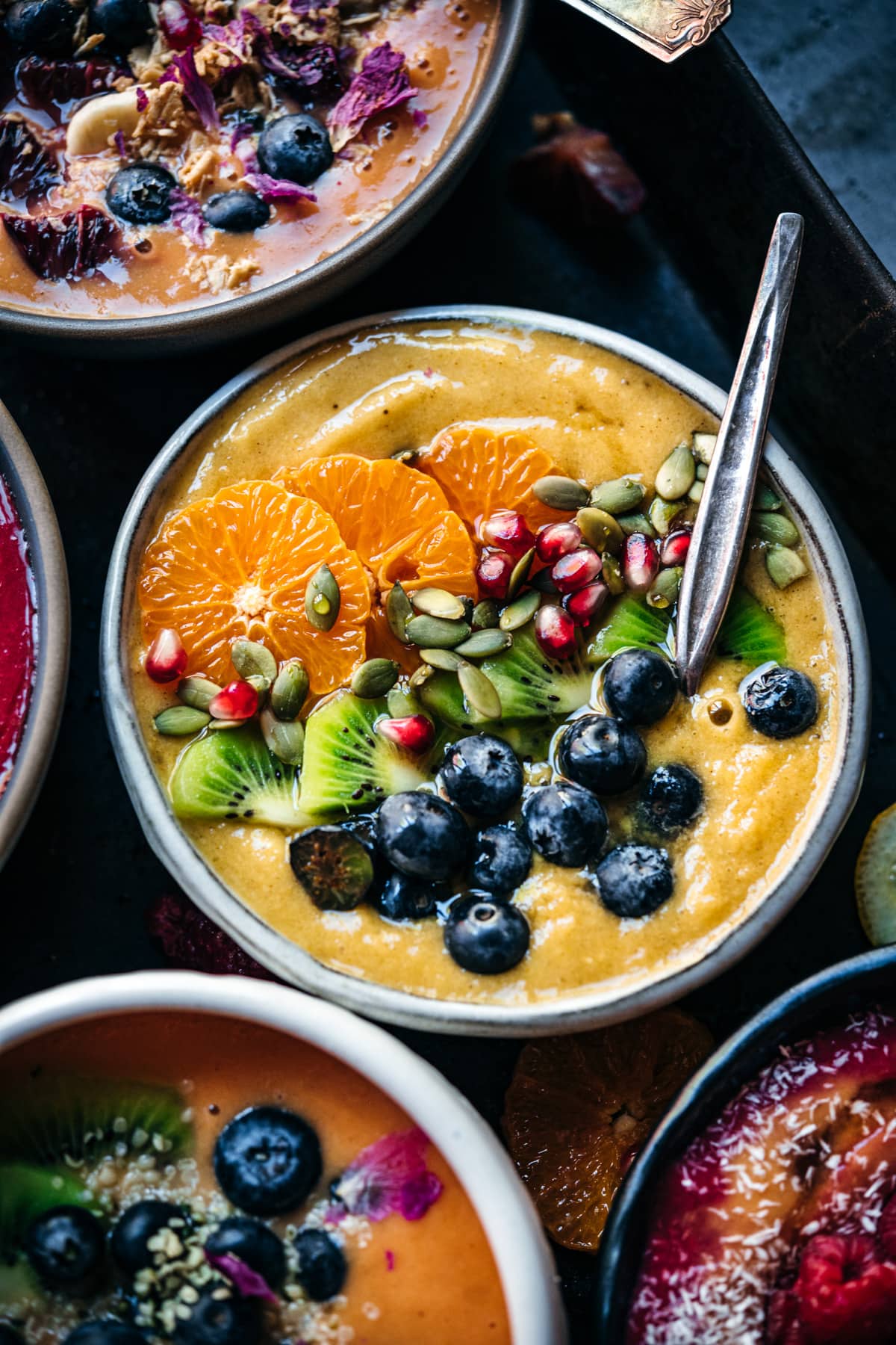 overhead view of pineapple turmeric smoothie bowl topped with fresh berries. 
