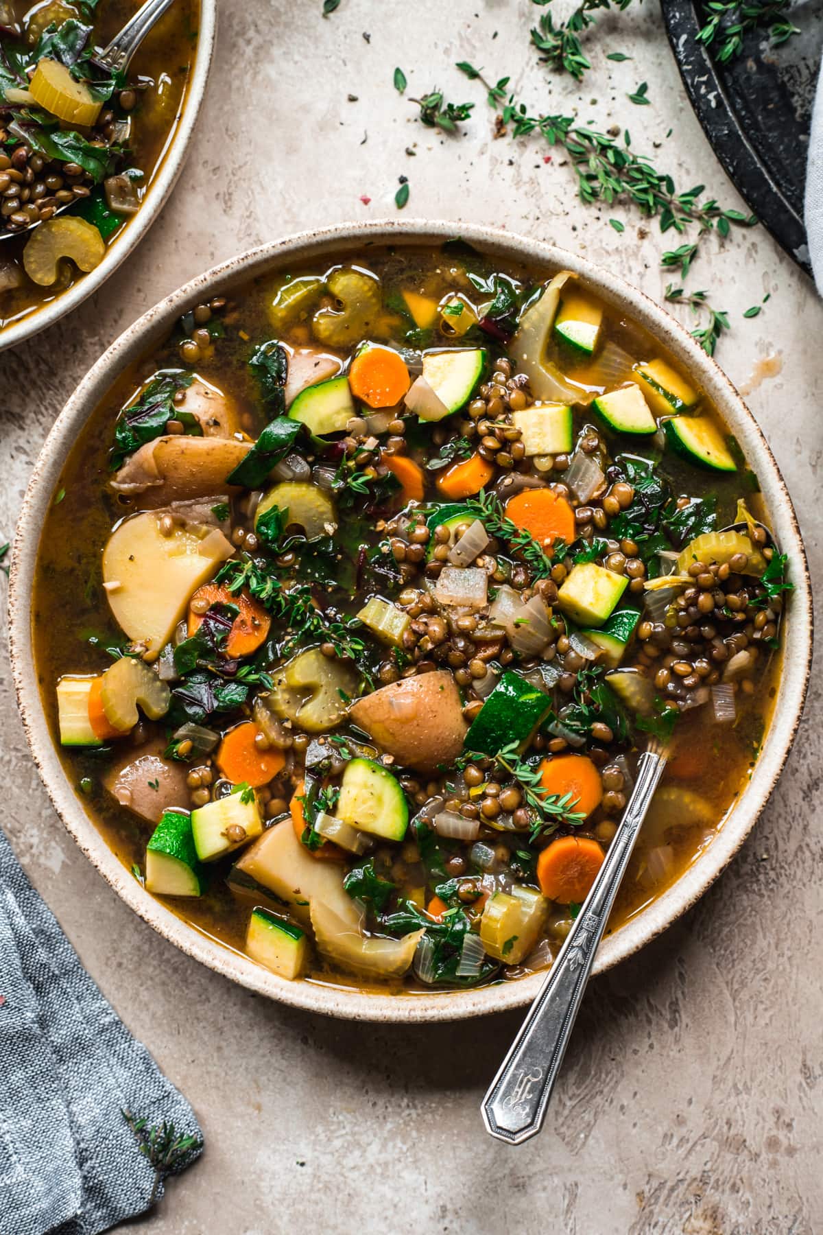 close up overhead view of lentil vegetable soup in a bowl with spoon.