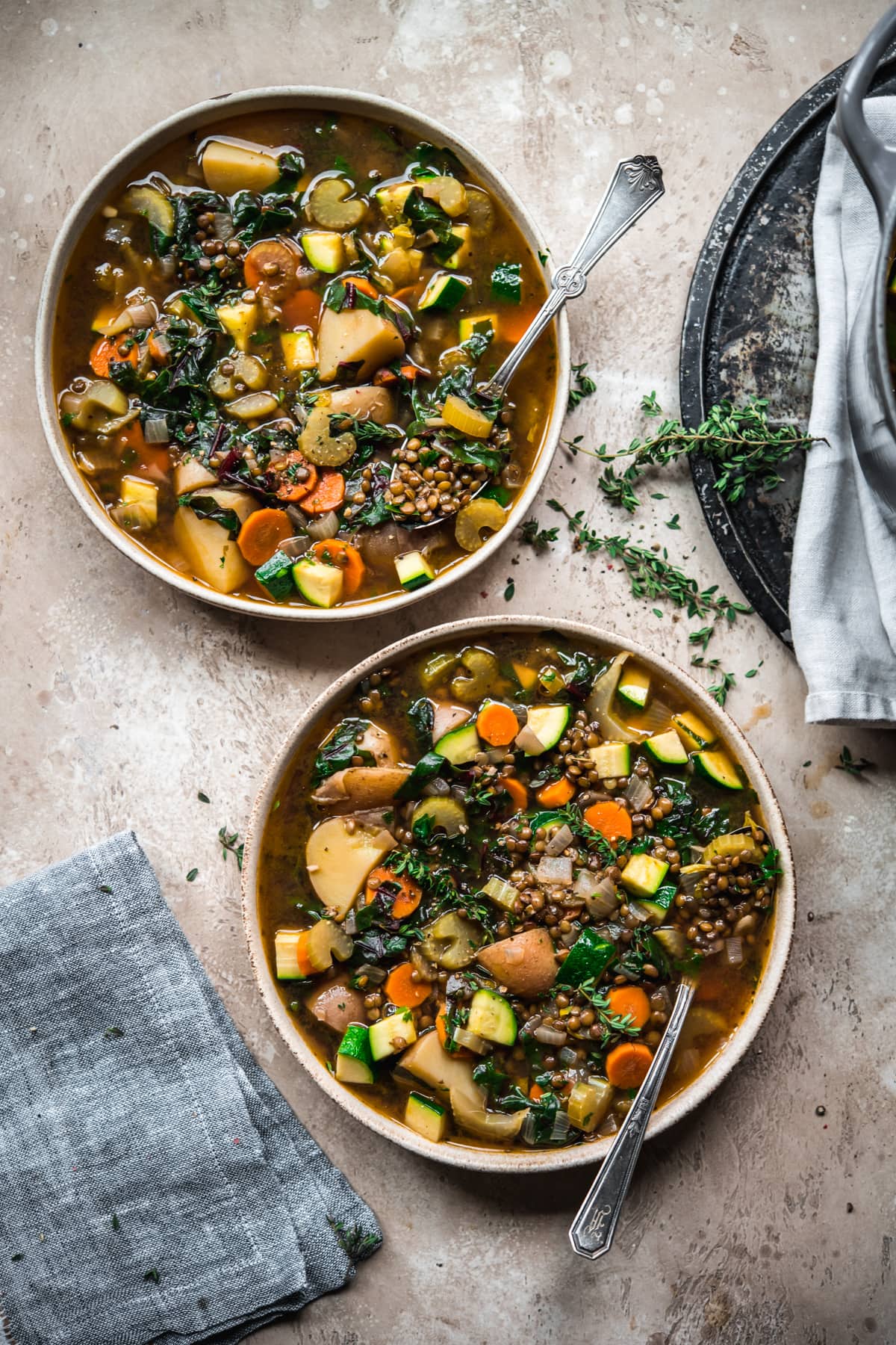 close up overhead view of two bowls of lentil vegetable soup.