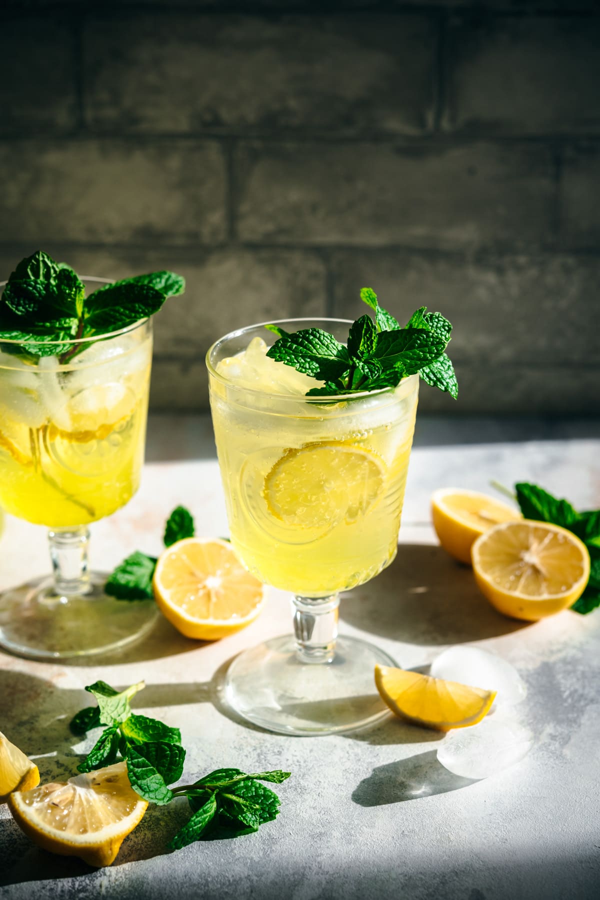 side view of limoncello spritz cocktail garnished with fresh mint. 