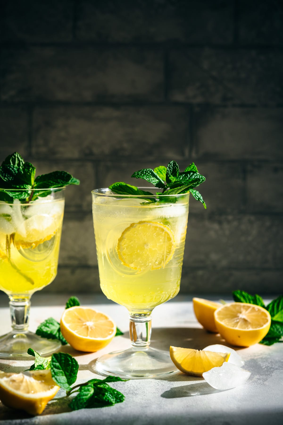 side view of limoncello spritz cocktail garnished with fresh mint. 