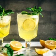 side view of limoncello spritz cocktail garnished with fresh mint.