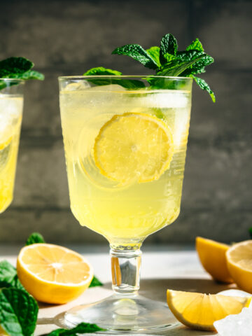 side view of limoncello spritz cocktail garnished with fresh mint.