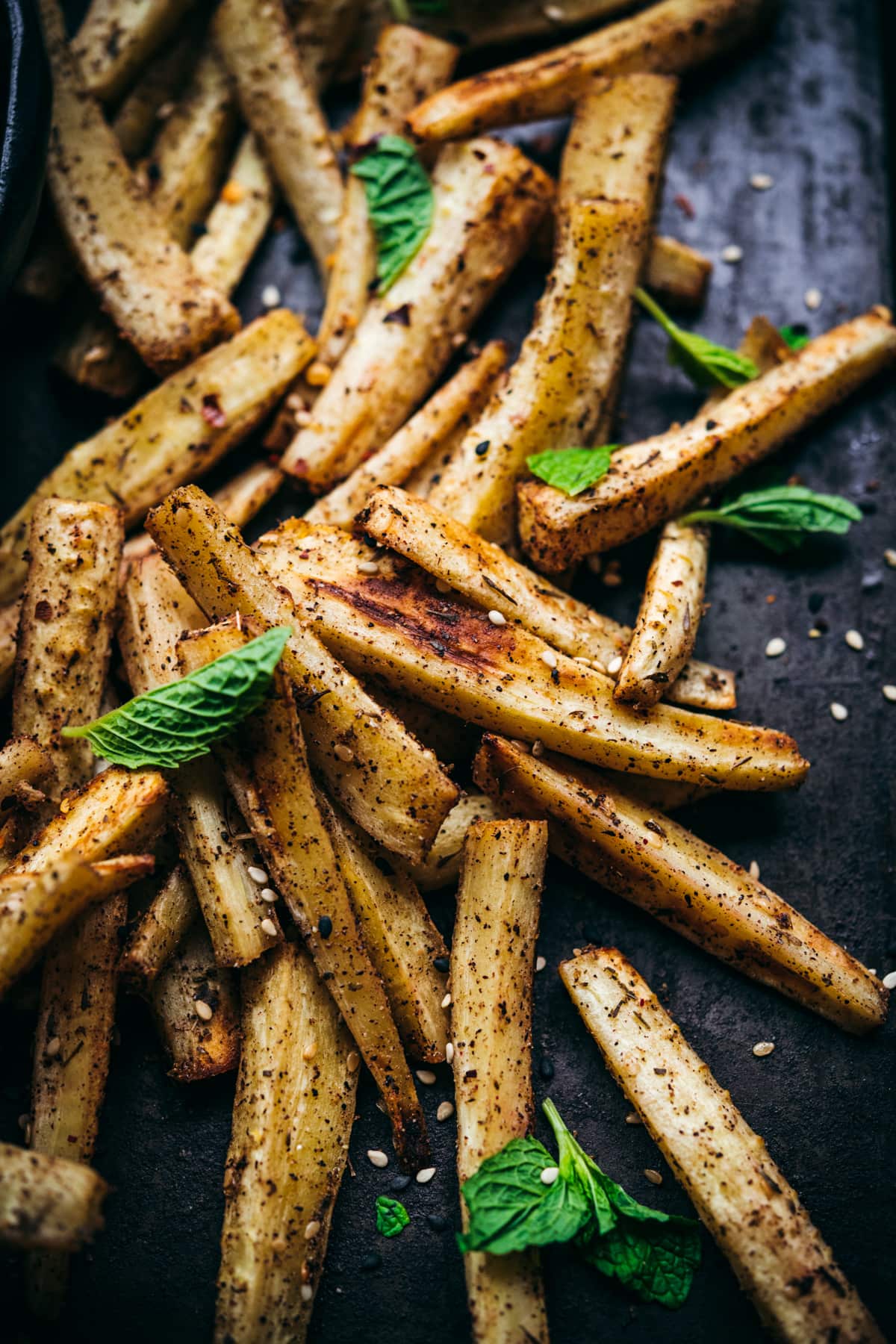 close up view of roasted parsnips on sheet pan. 