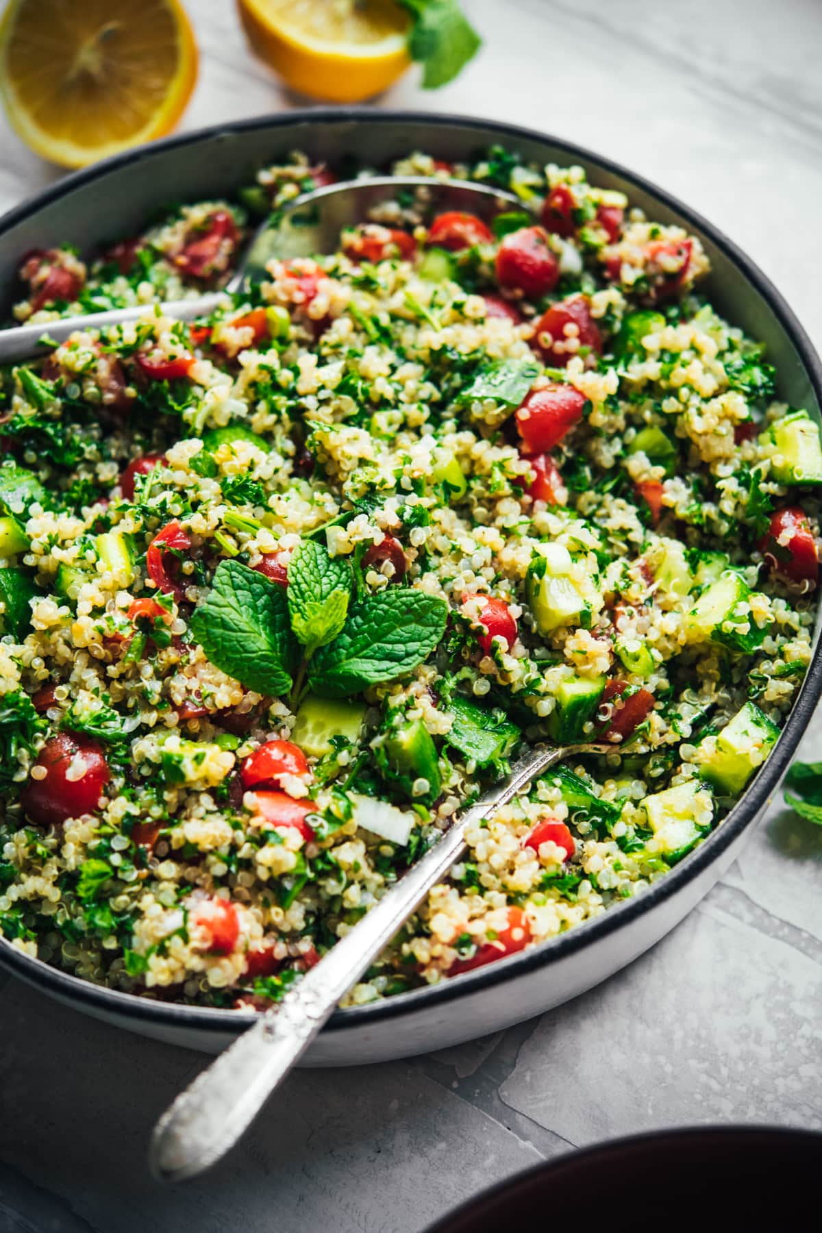 close up side view of quinoa tabbouleh in a salad bowl. 