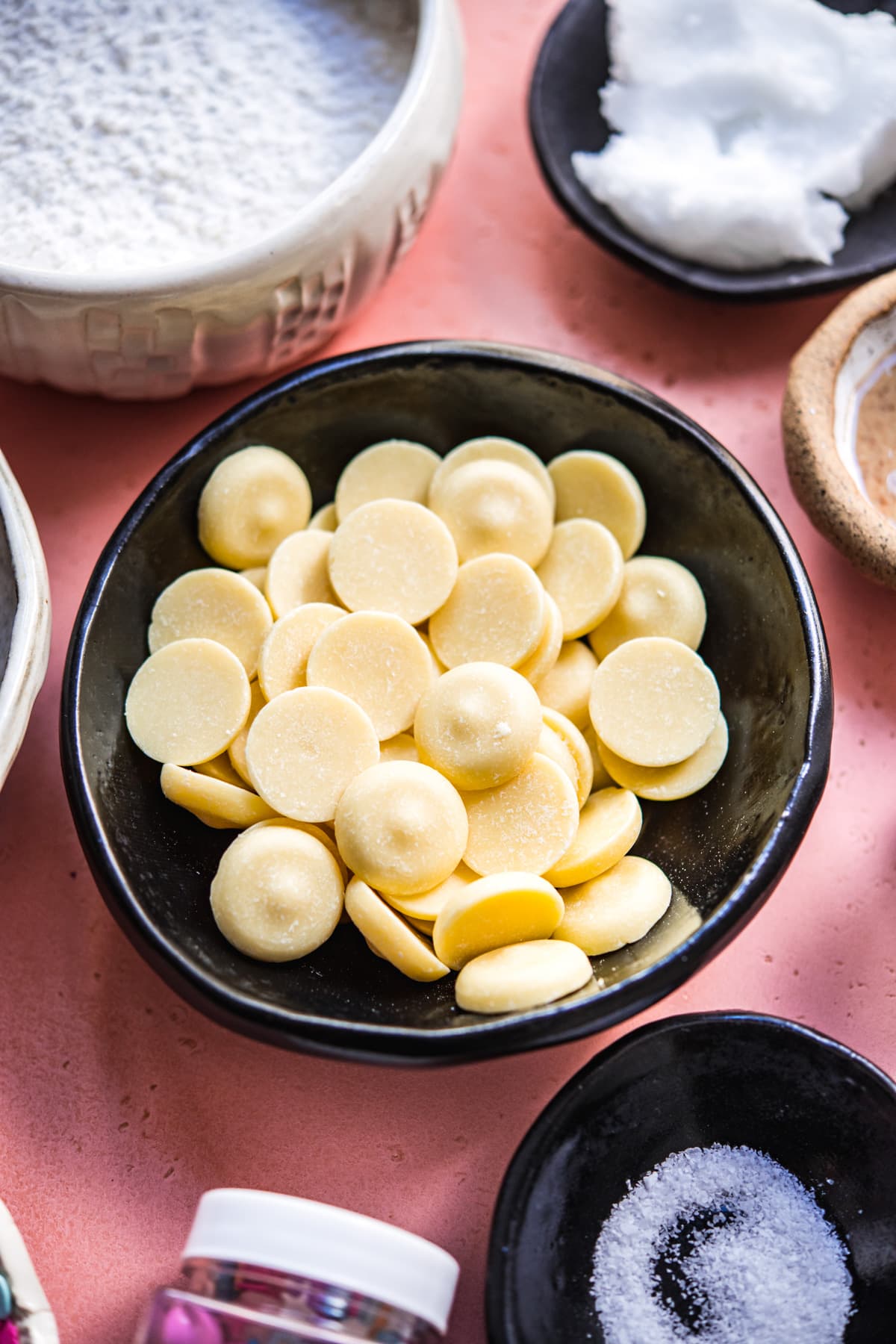 close up view of cacao butter wafers in a bowl.