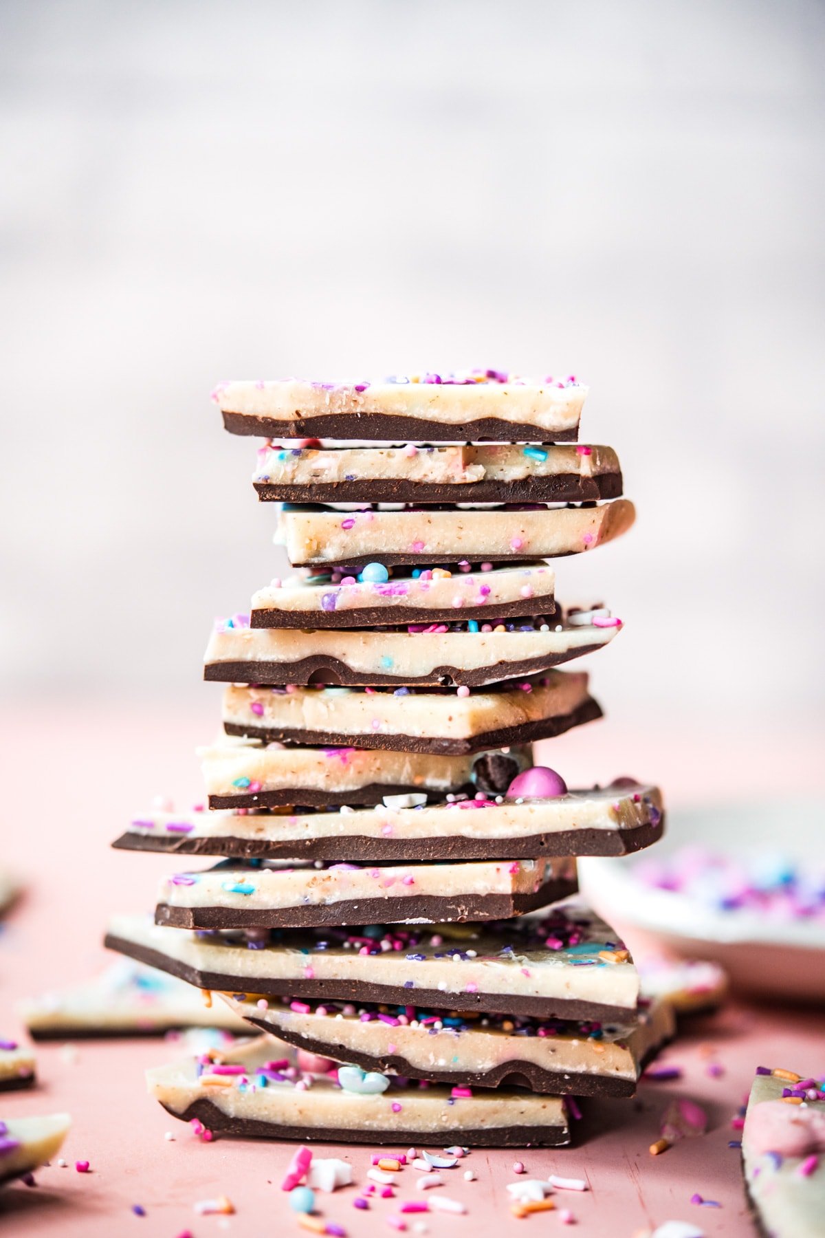 side view of stack of vegan white chocolate bark pieces.