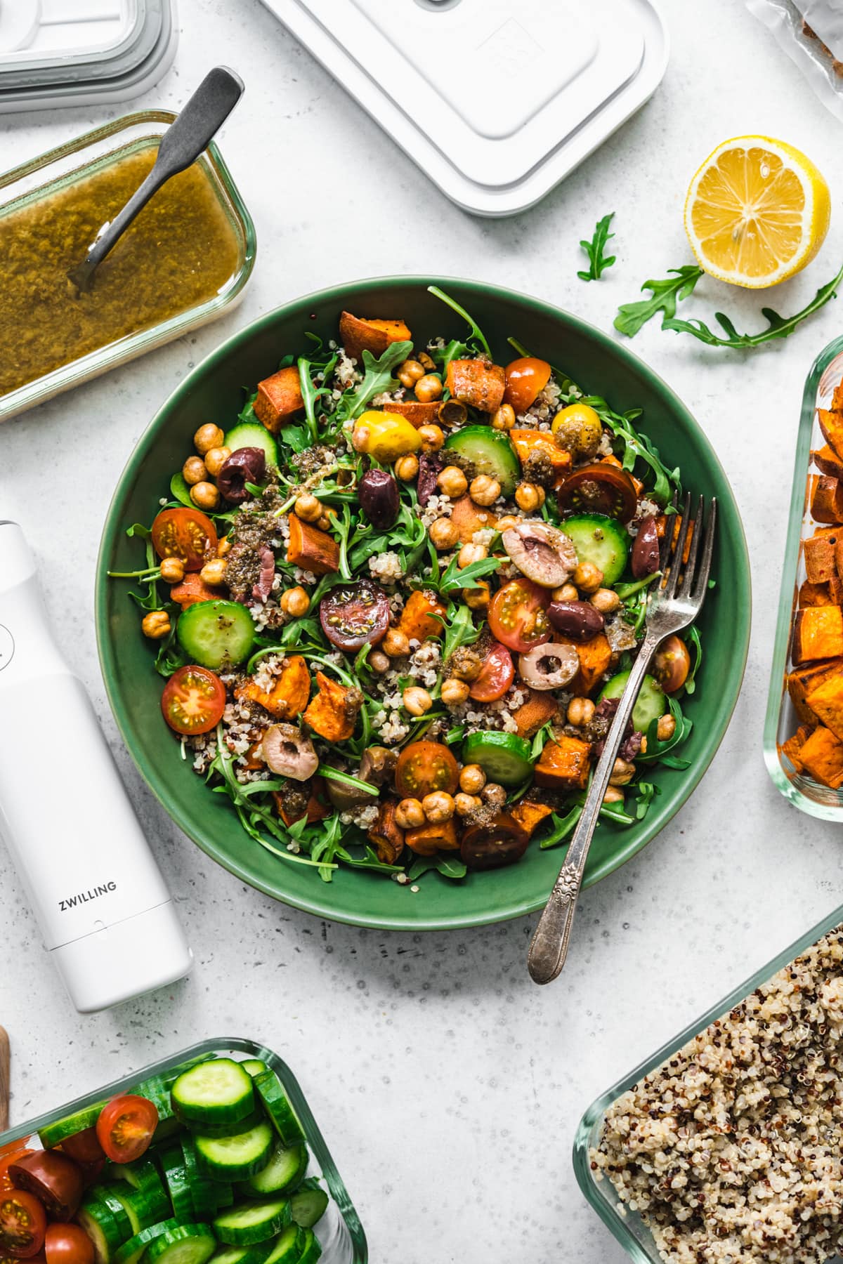 overhead view of quinoa arugula and sweet potato salad in a green bowl. 