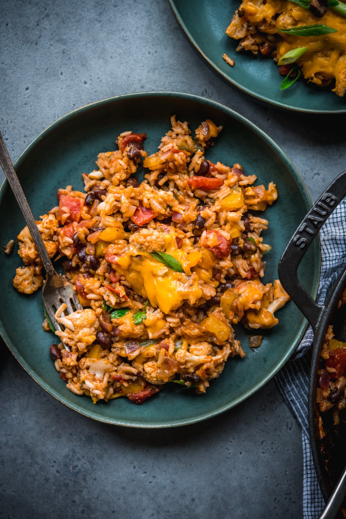 overhead view of vegan cauliflower rice black bean bake on a plate. 