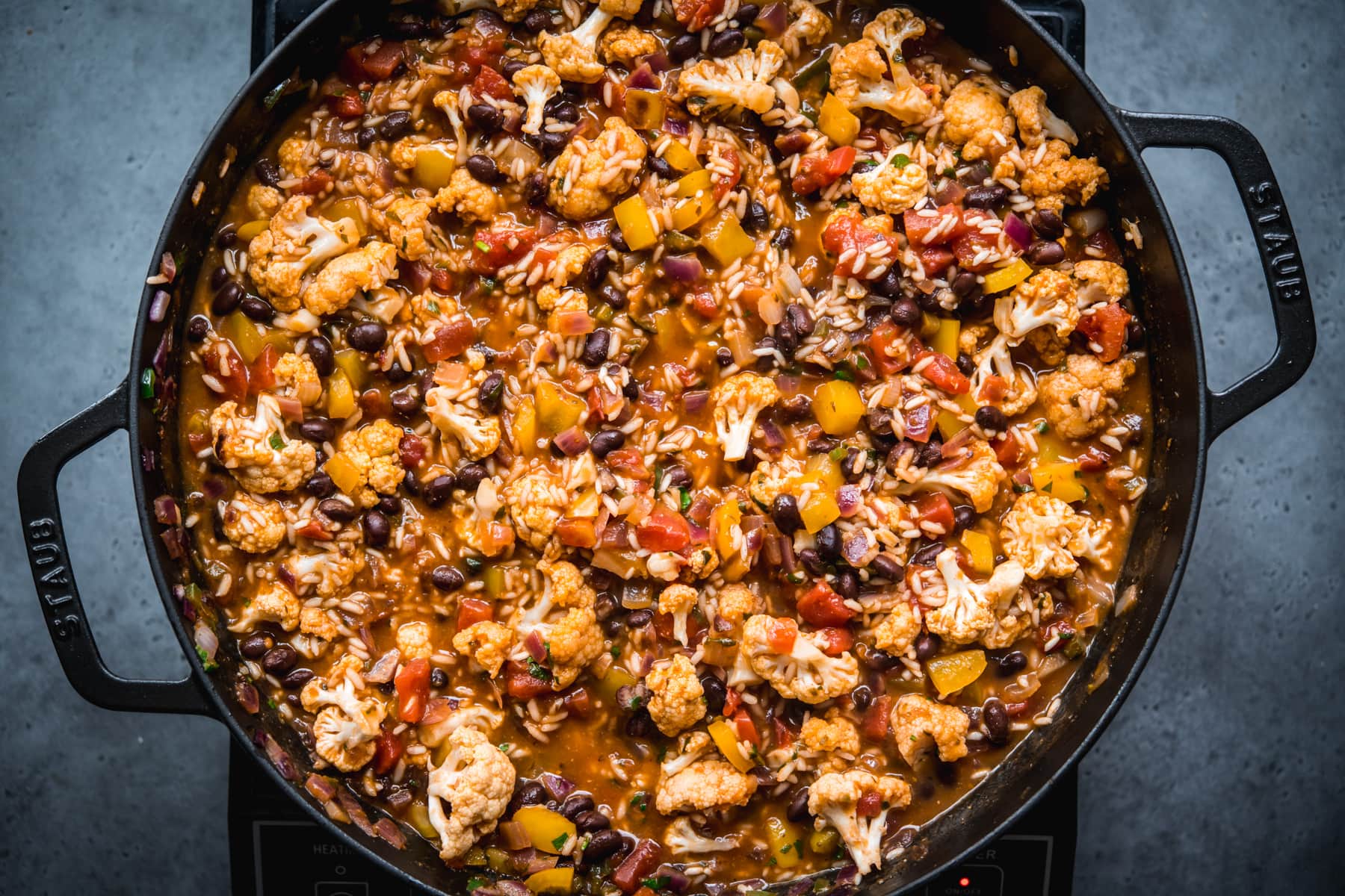 overhead view of cauliflower black bean and rice bake in large skillet.