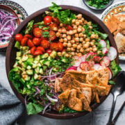 overhead view of chickpea fattoush salad with pita chips in wood salad bowl.