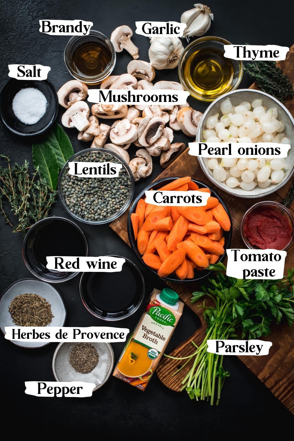 overhead view of ingredients for vegan coq au vin including mushrooms, carrots, pearl onions and wine.