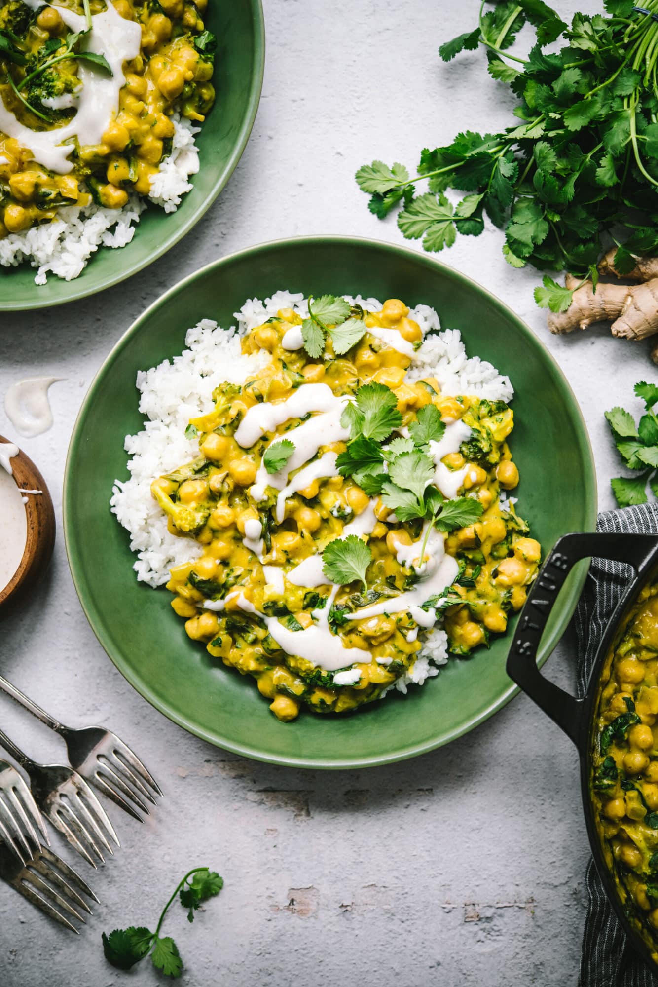 overhead view of vegan mango chickpea curry over white rice in a green bowl.