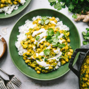 overhead view of vegan mango chickpea curry over white rice in a green bowl.