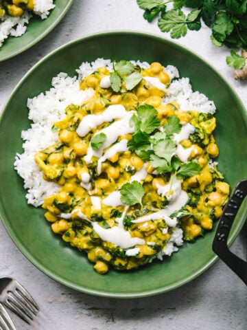 overhead view of vegan mango chickpea curry over white rice in a green bowl.