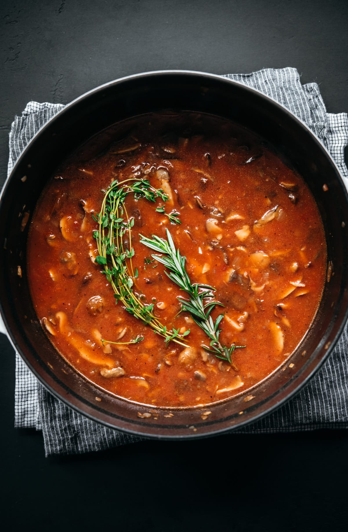 overhead view of vegan mushroom ragu in large dutch oven before cooking down.