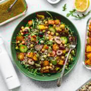 overhead view of quinoa arugula and sweet potato salad in a green bowl.