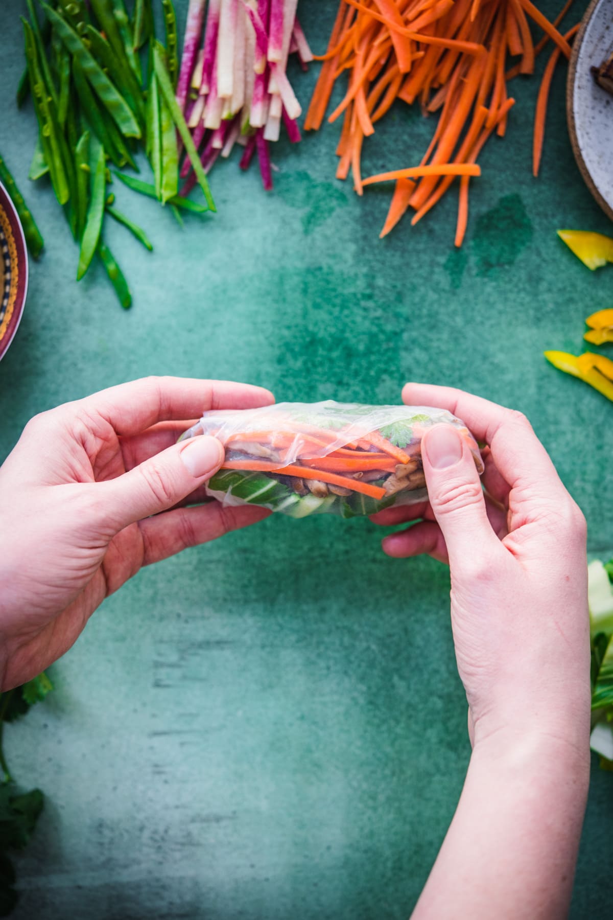 person holding up vegan summer roll. 