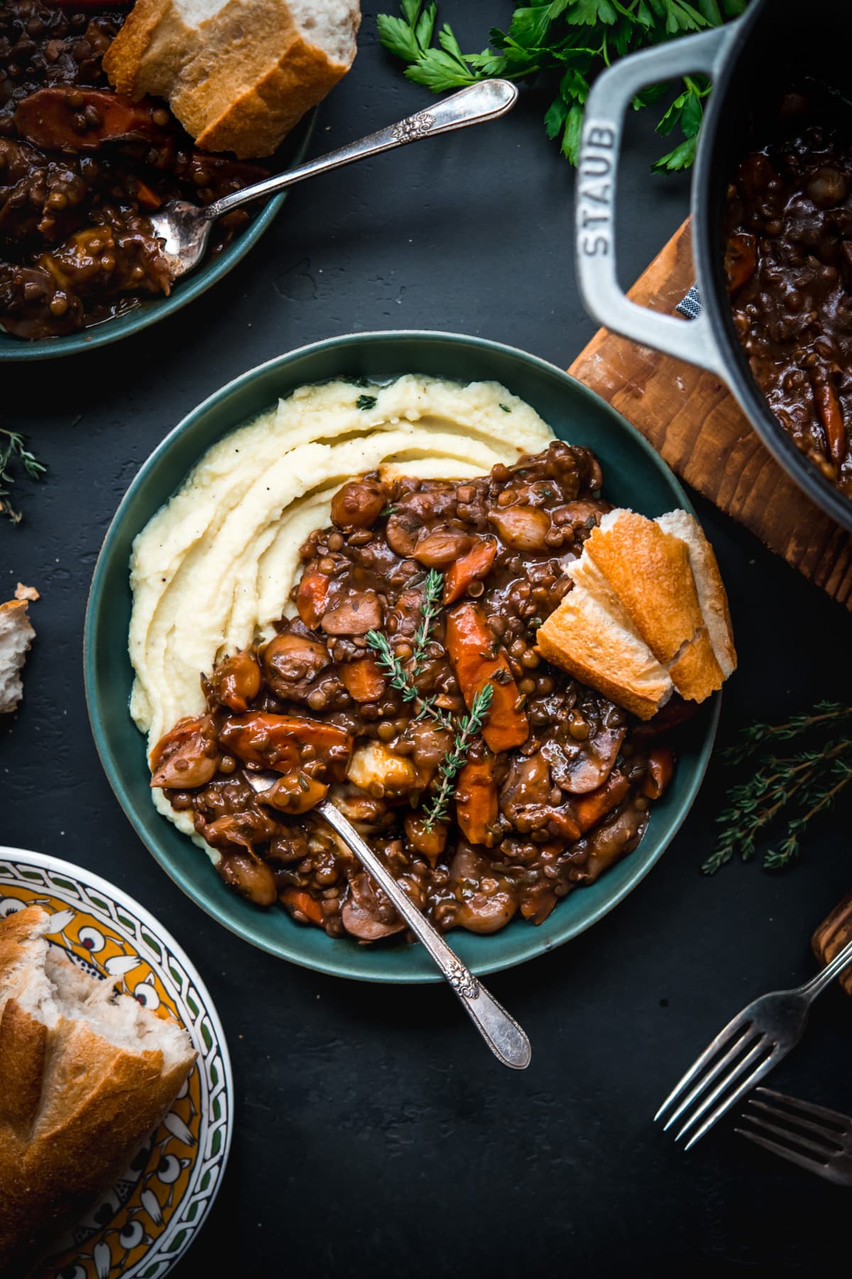 overhead view of vegan lentil and mushrooom coq au vin over mashed potatoes in a bowl. 