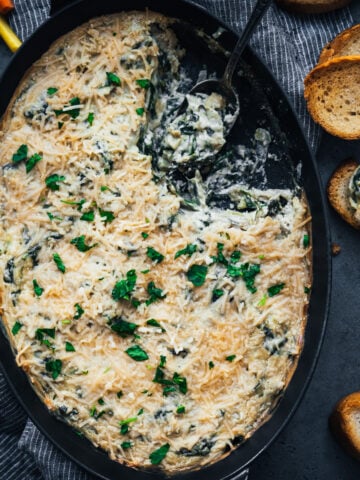 overhead view of vegan spinach artichoke dip in a skillet.