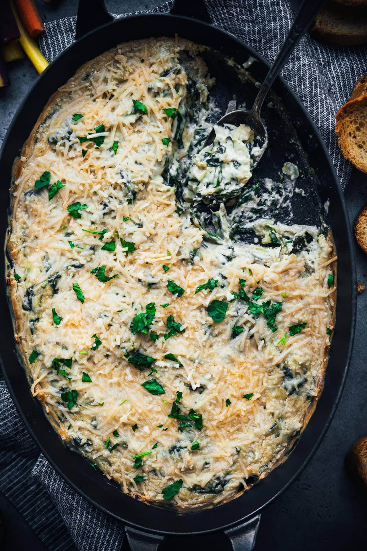 overhead view of vegan spinach artichoke dip in a skillet. 