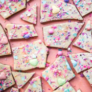 overhead view of vegan white chocolate bark broken into pieces topped with sprinkles.