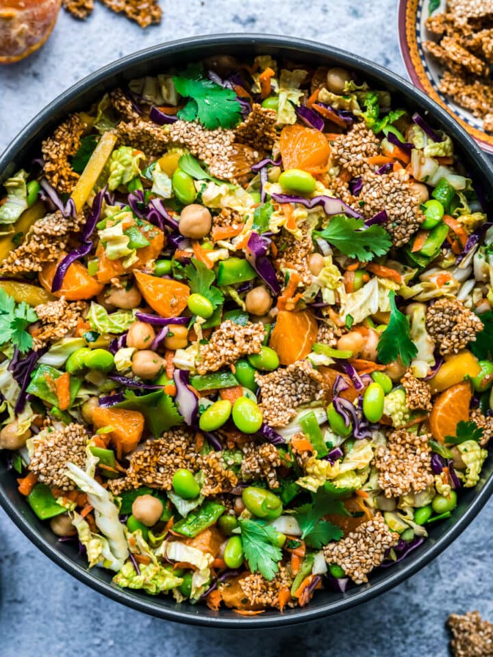overhead view of vegan sesame chickpea salad in a large bowl with edamame, cabbage and sesame brittle.
