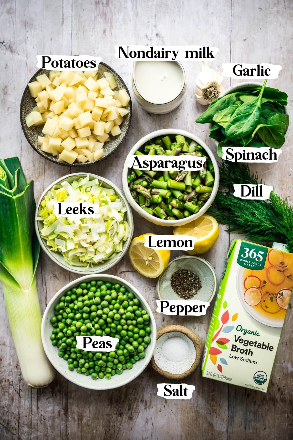 overhead view of ingredients for vegan asparagus soup on wood surface. 