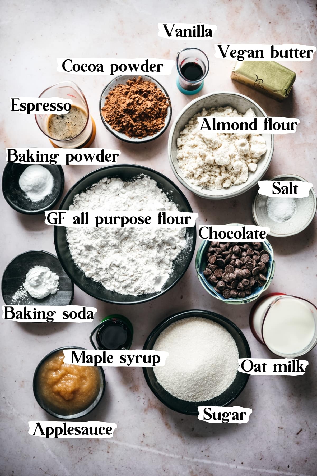 overhead view of ingredients to make vegan chocolate cake, including flour, vegan butter, applesauce, chocolate, cocoa powder. 