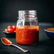 close up side view of homemade taco sauce in glass mason jar.