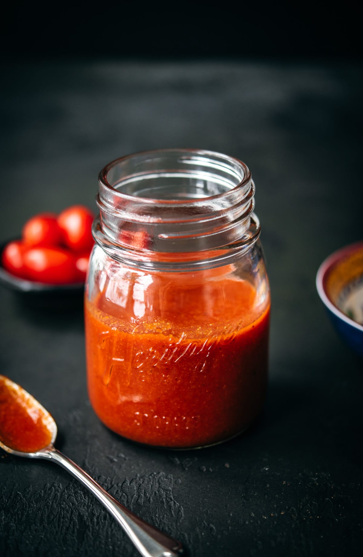 close up side view of homemade taco sauce in glass mason jar. 