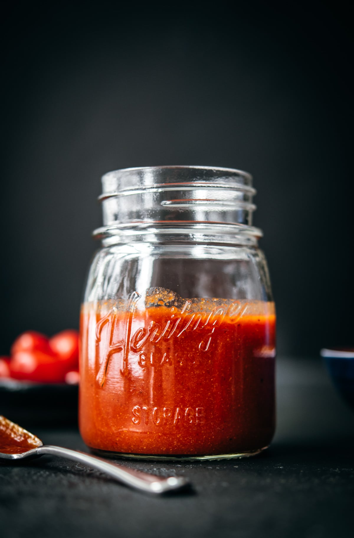 close up side view of homemade taco sauce in glass mason jar. 