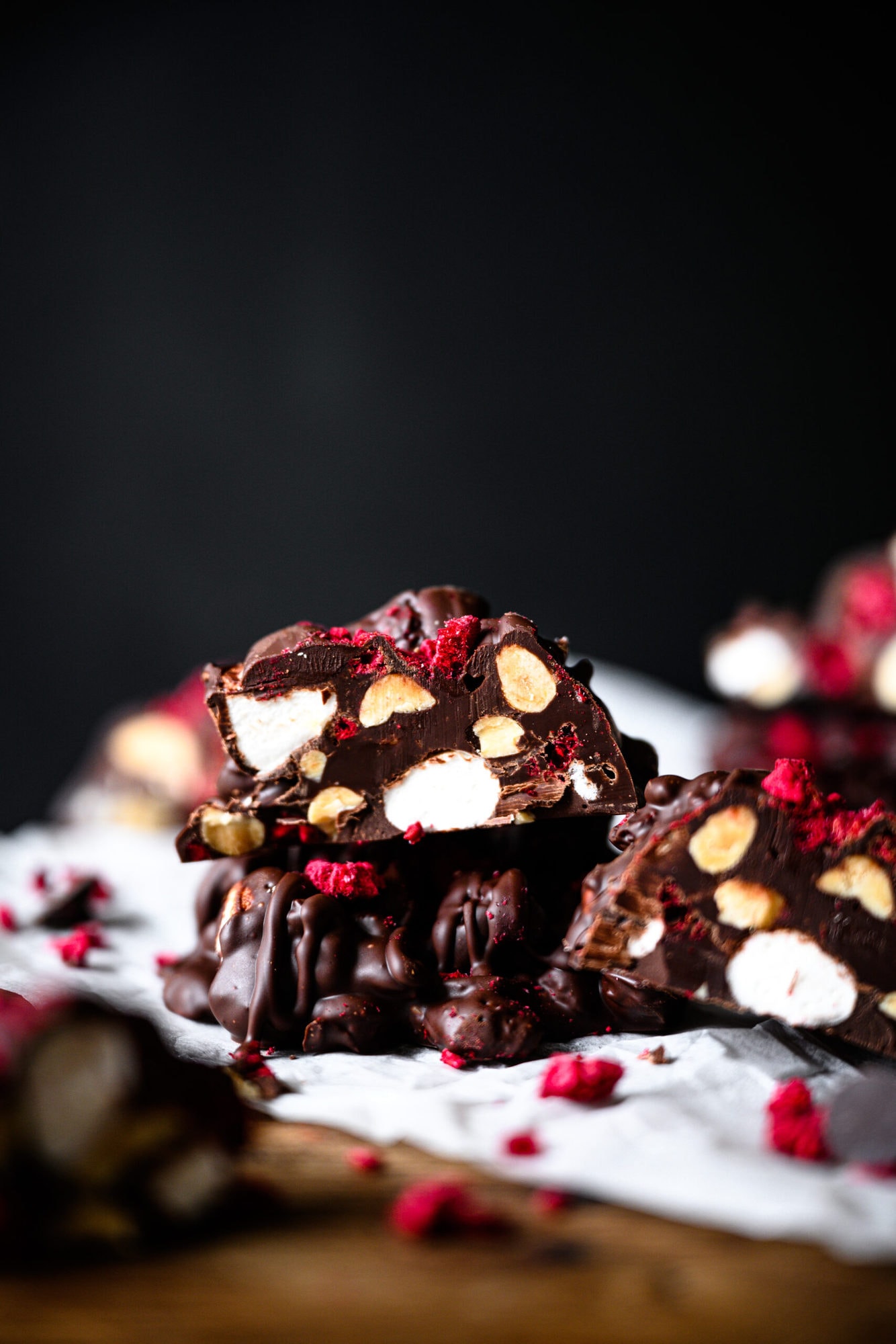 stack of dark chocolate peanut marshmallow clusters with freeze dried raspberries.