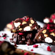 stack of dark chocolate peanut marshmallow clusters with freeze dried raspberries.