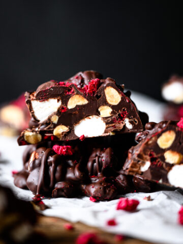 stack of dark chocolate peanut marshmallow clusters with freeze dried raspberries.