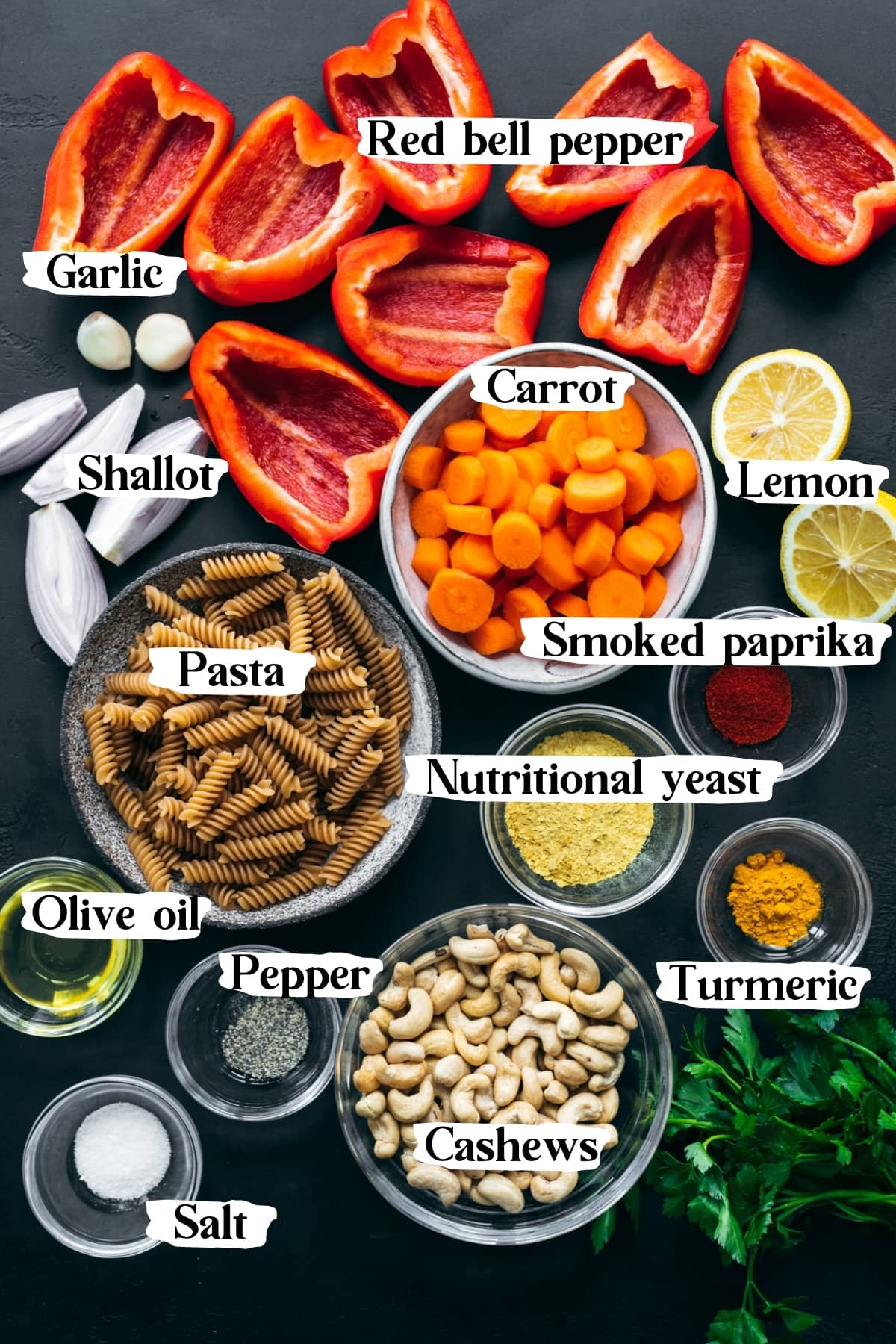 overhead view of ingredients for vegan roasted red pepper pasta in small bowls with text labels. 