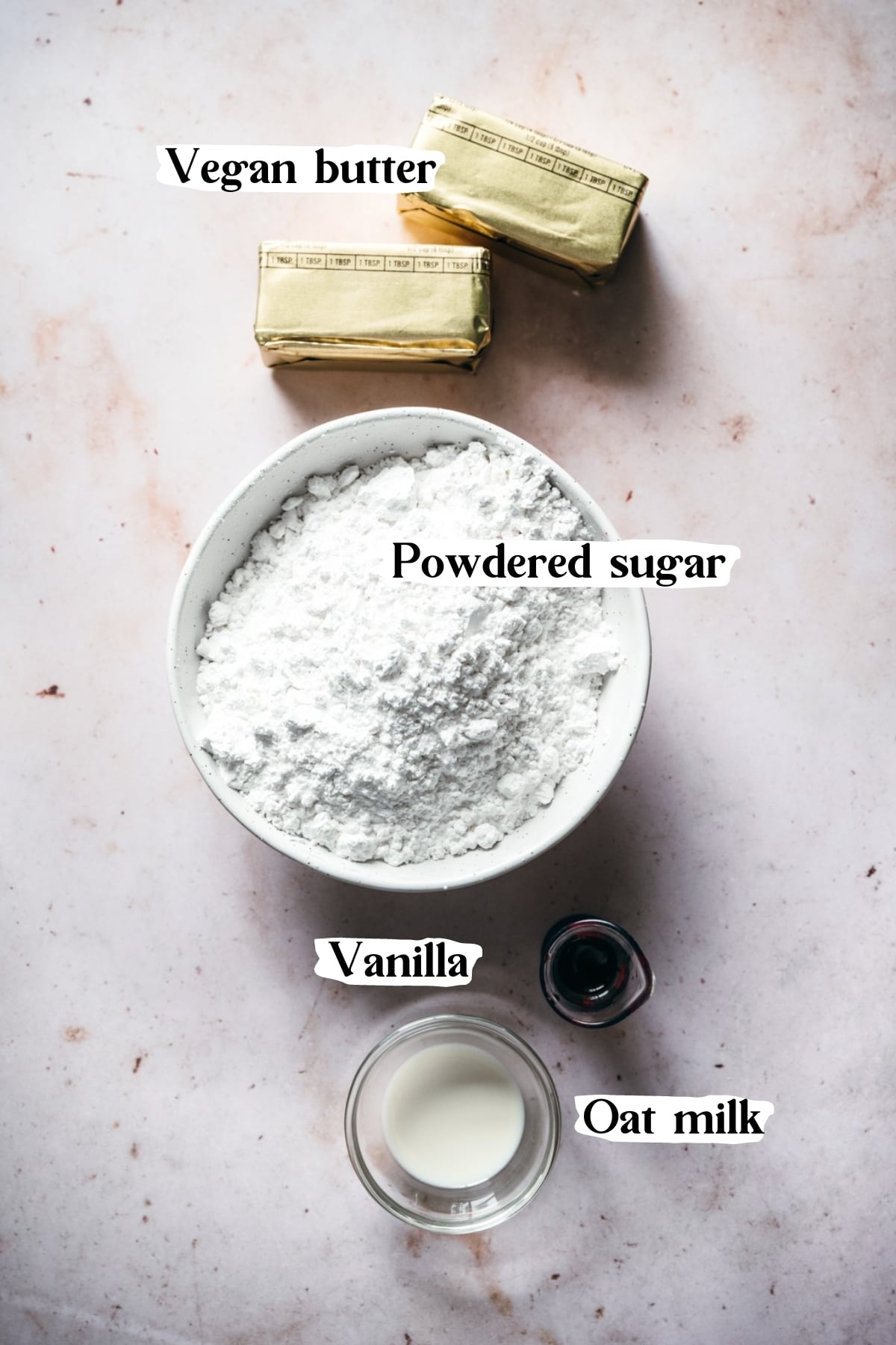 overhead view of ingredients to make vegan frosting, including vegan butter, powdered sugar, vanilla and milk.