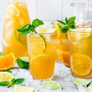 Two glasses of long island iced tea with mint, lemon and lime.