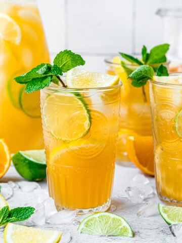 Two glasses of long island iced tea with mint, lemon and lime.