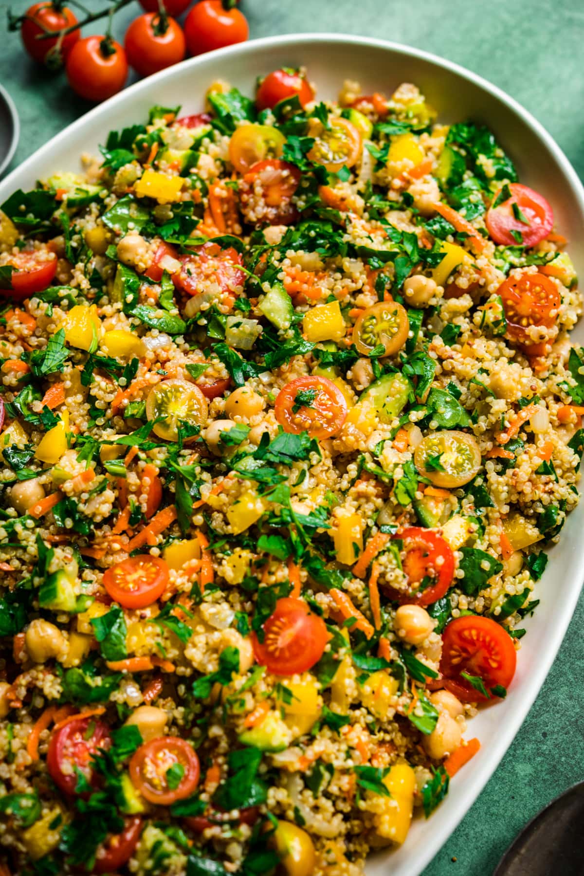 close up view of quinoa chickpea vegetable salad on a large white platter.