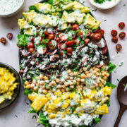 overhead view of vegan cobb salad on a platter topped with vegan ranch dressing.