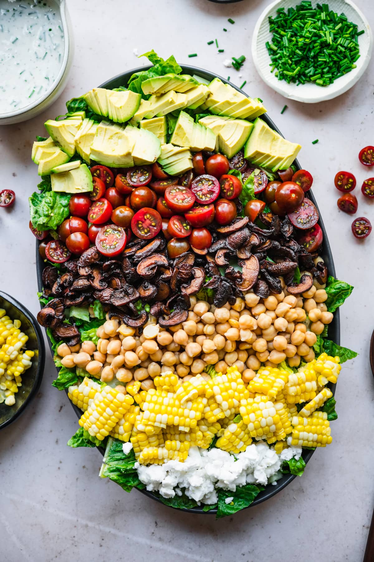 overhead view of vegan cobb salad on a platte with corn, chickpeas and mushroom bacon.