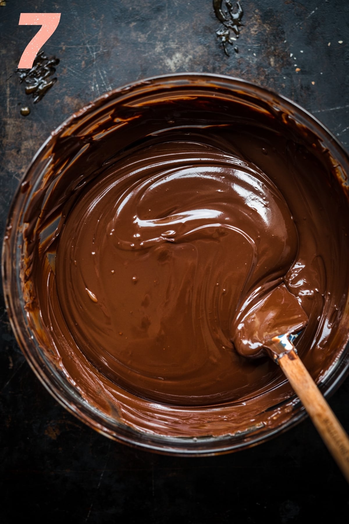 overhead view of bowl of melted chocolate with spatula in bowl. 