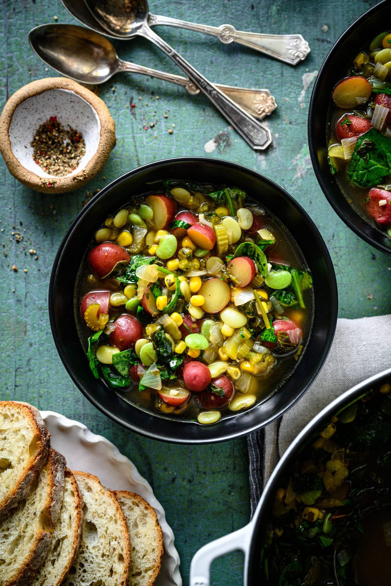 overhead view of bowl of vegan lima bean soup with potatoes and corn. 