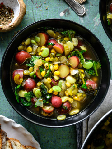 overhead view of bowl of vegan lima bean soup with potatoes and corn.