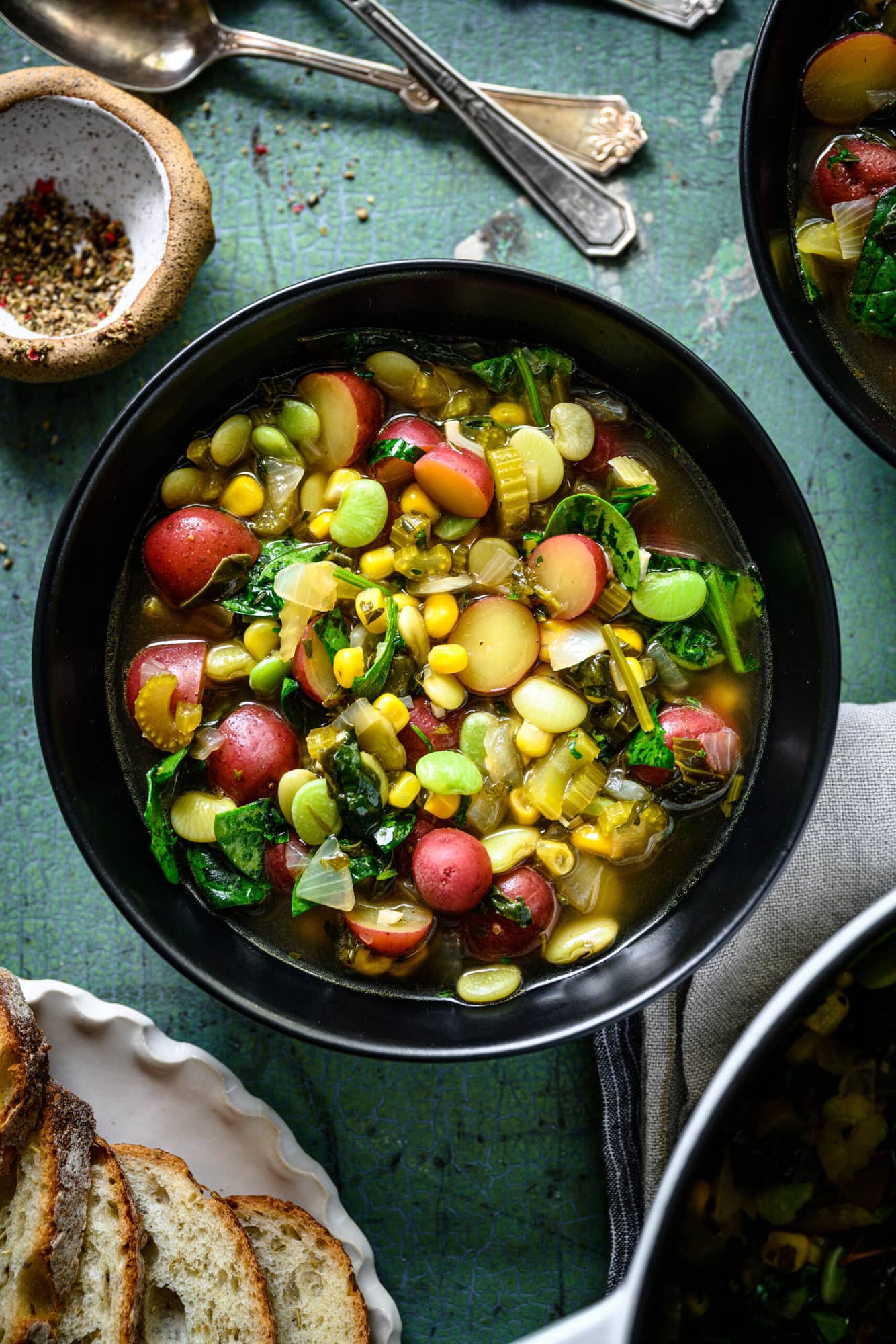 overhead view of bowl of vegan lima bean soup with potatoes and corn.