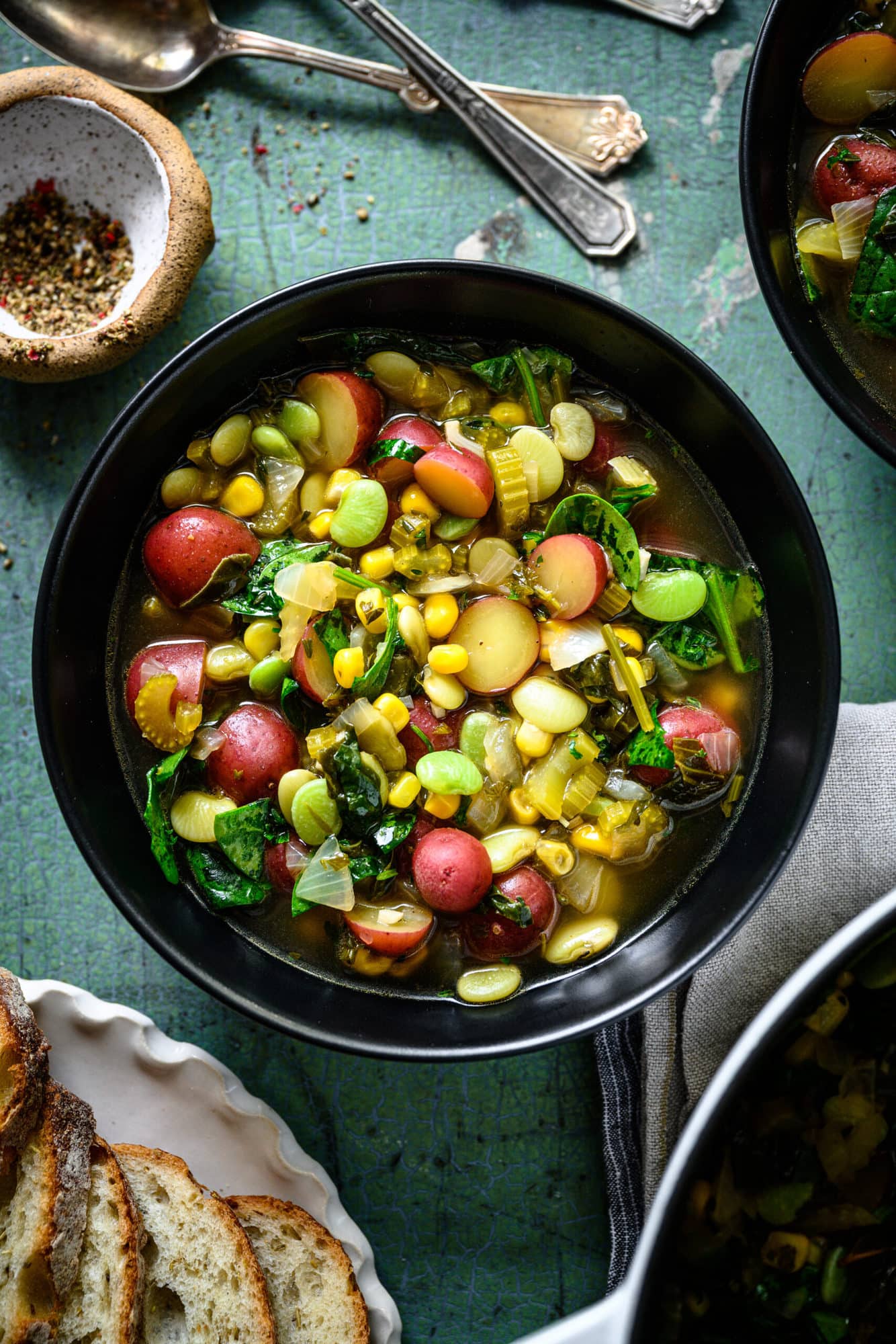 overhead view of bowl of vegan lima bean soup with potatoes and corn. 