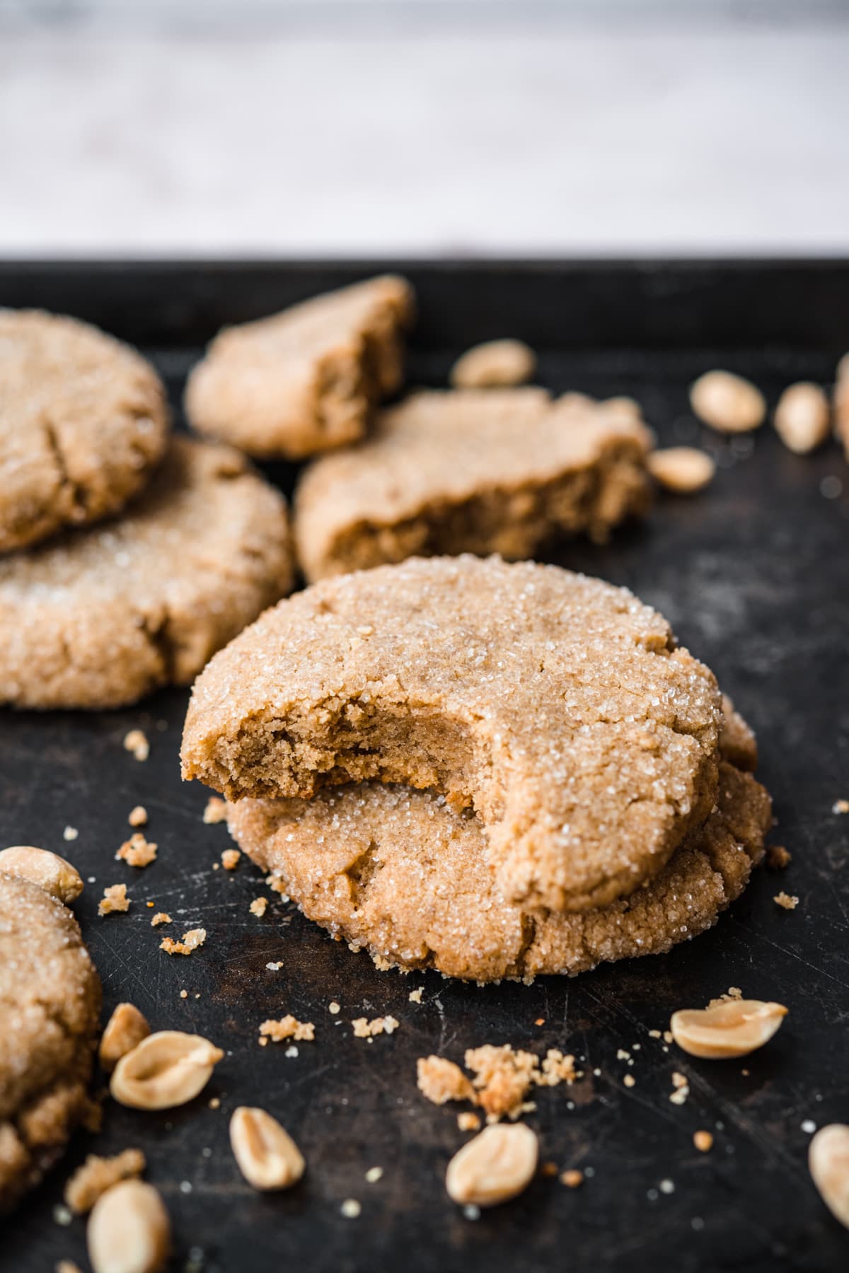 close up view of two stacked vegan peanut butter cookies with bite taken out. 